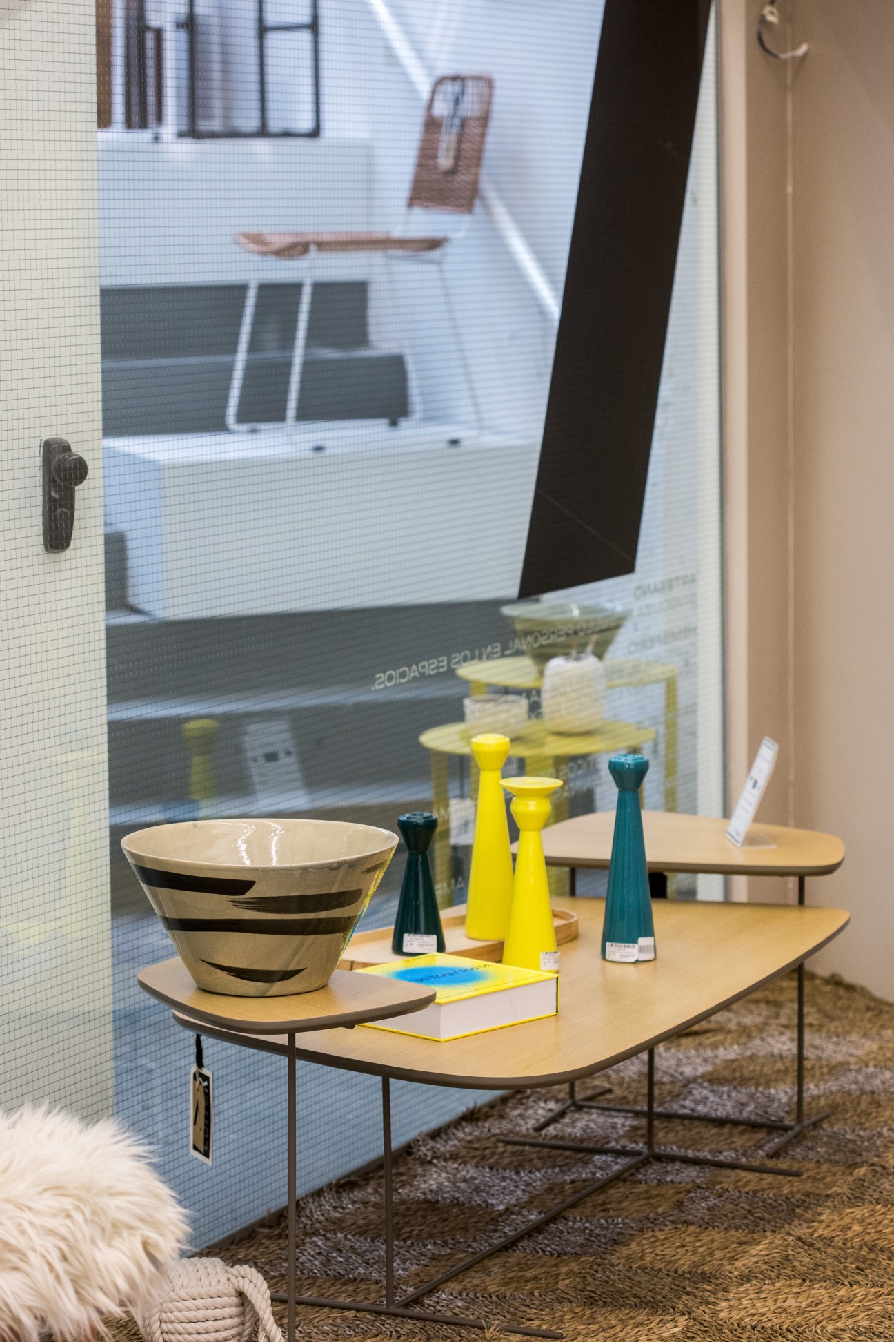 Display table with striped bowl, yellow and teal vases, and white book at Editor Market Buenos Aires showroom
