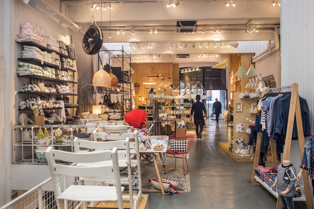 Interior of Editor Market showing retail space with clothing displays, seating area, and shoppers browsing merchandise.