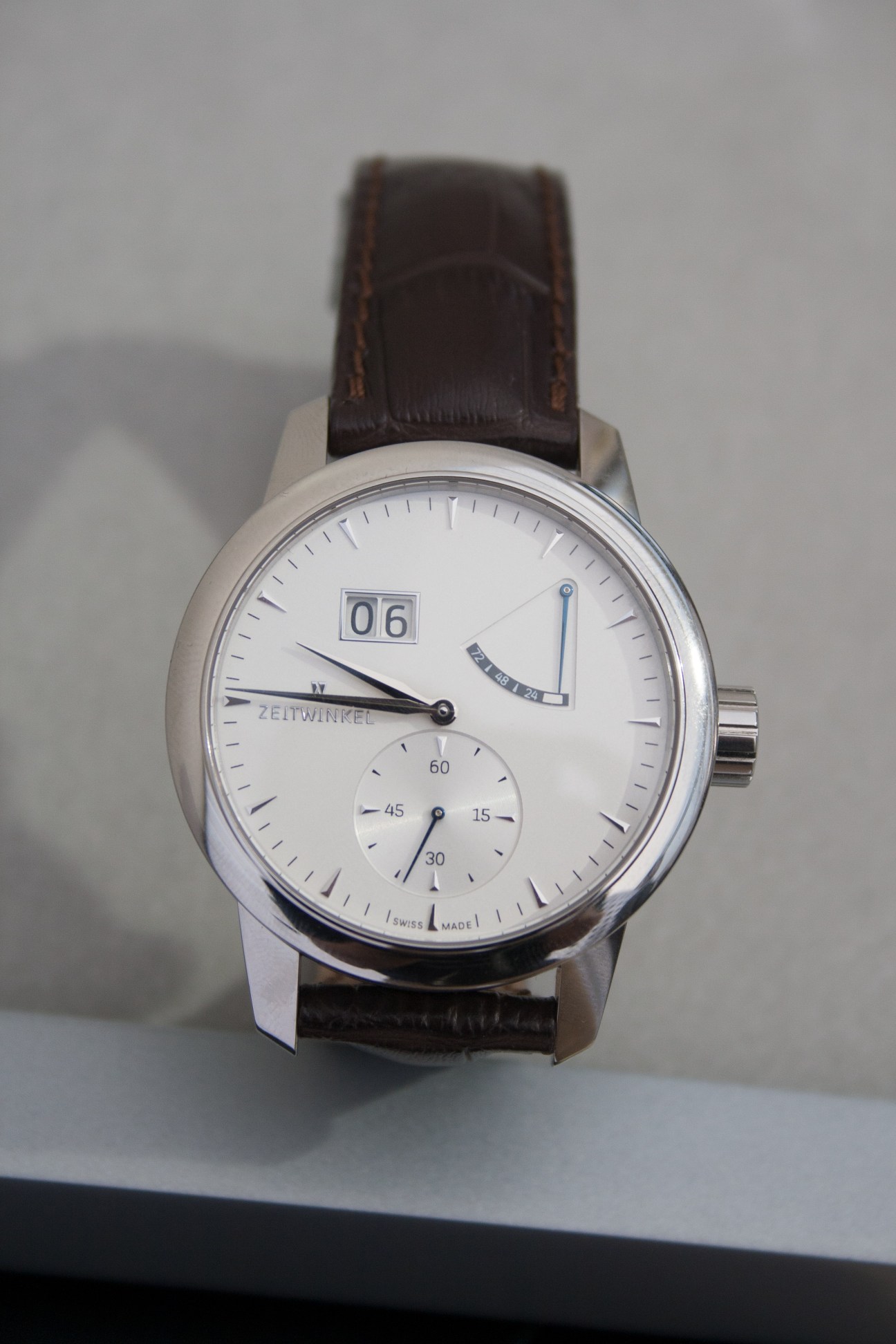 Zeitwinkel 273˚ watch with silver case, white dial, big date indicator and dark leather strap.