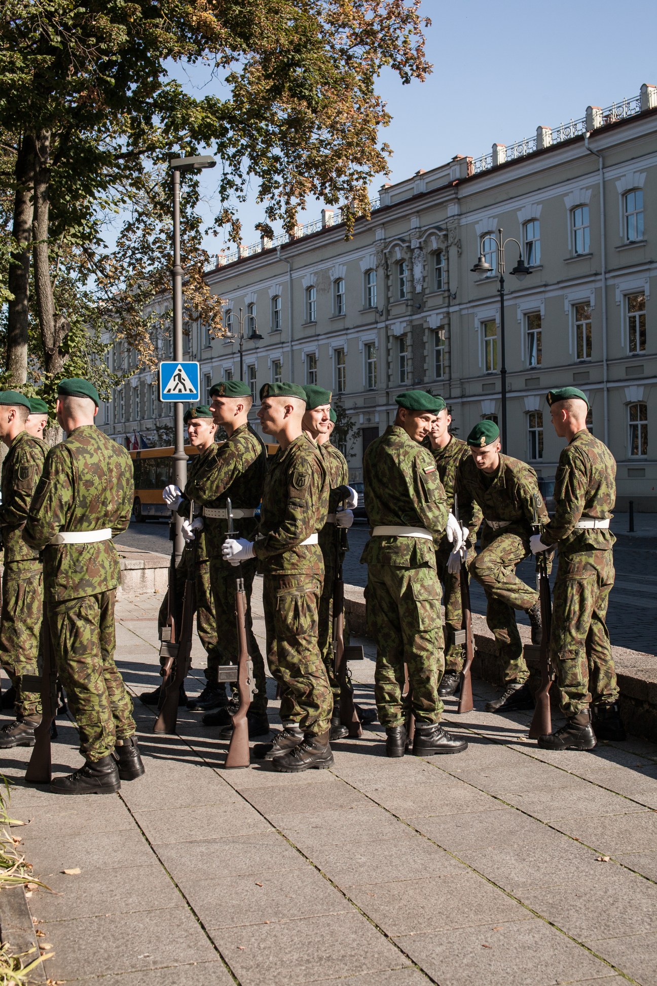Lithuanian soldiers in camouflage uniforms gather on a street in Vilnius during a military drill.