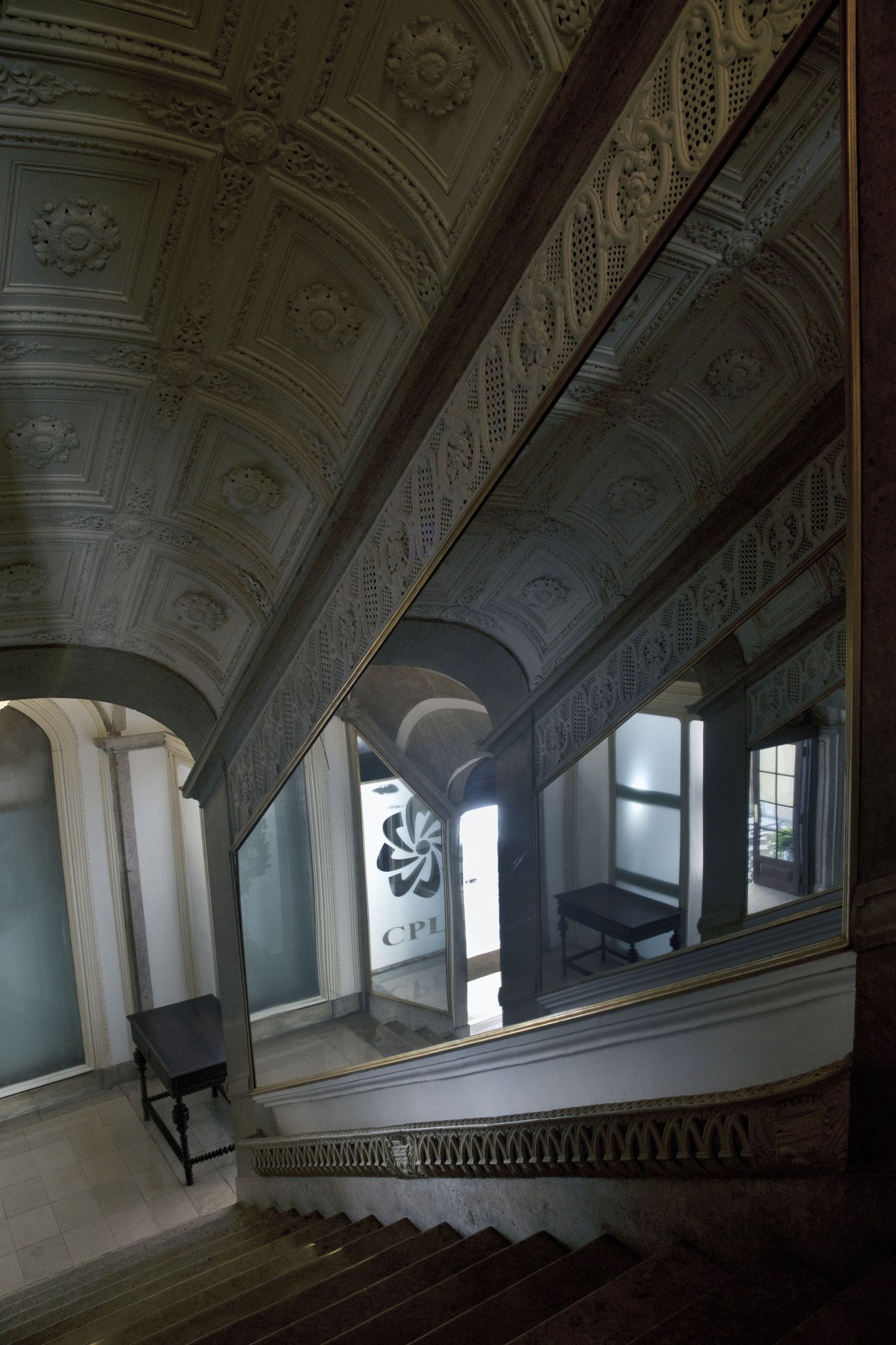 Ornate marble staircase with decorated ceiling in the Palácio Conde de Penafiel.