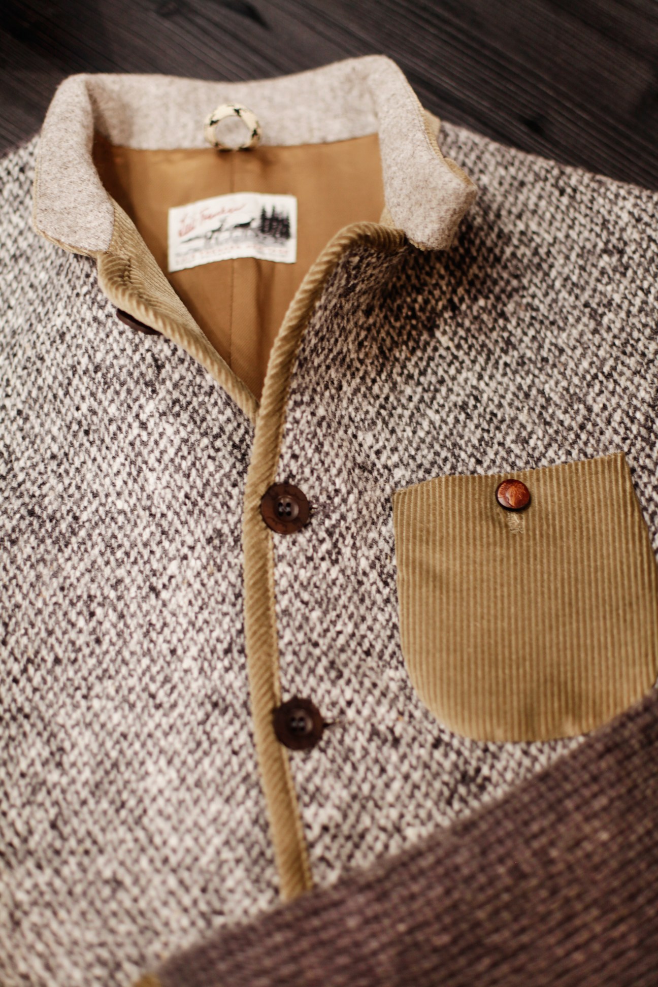 Close-up of a traditional alpine jacket by Luis Trenker with cream wool, tan collar, and wooden buttons.