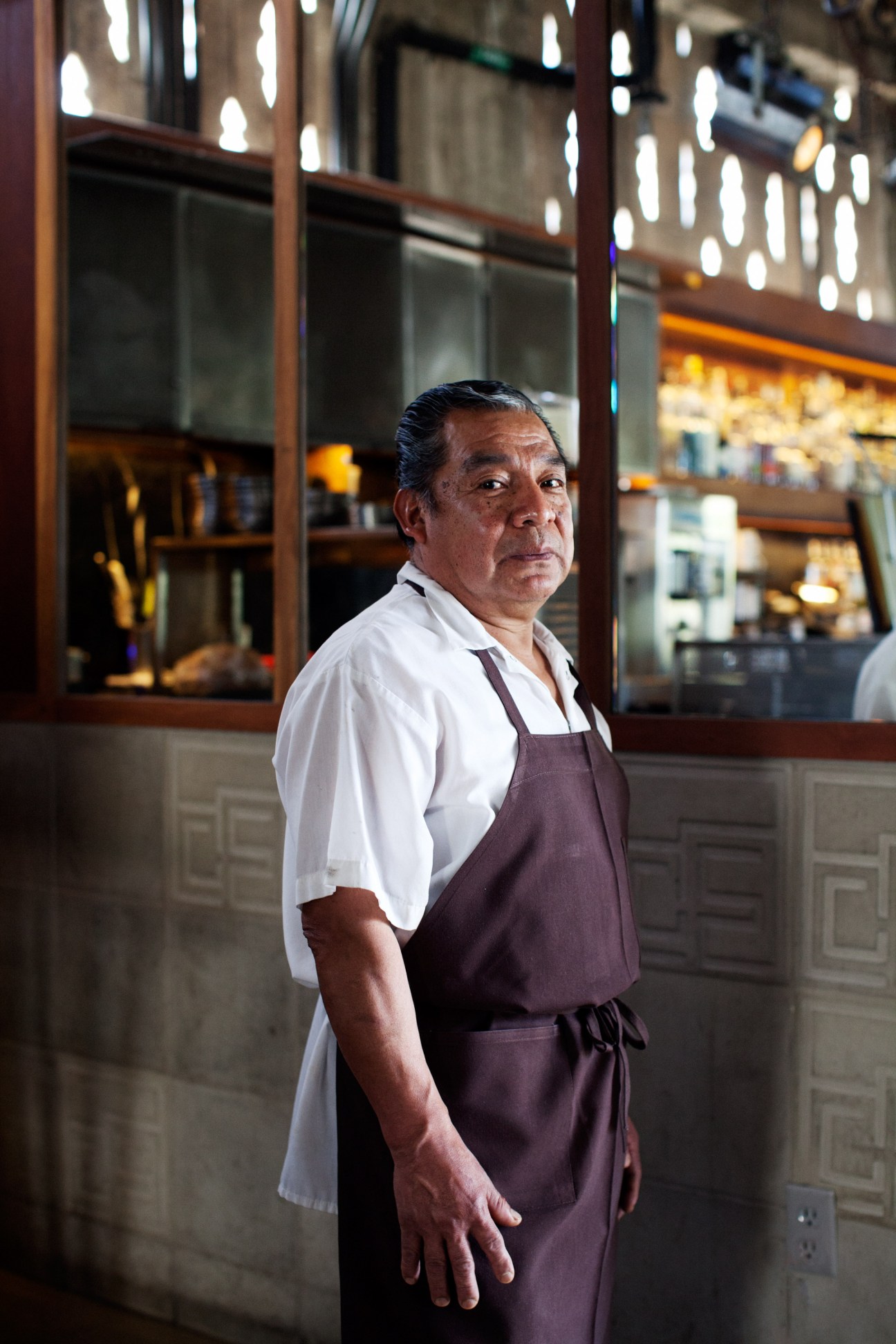 Flavio Poblano, F&B steward at Ace Hotel, wearing a burgundy apron and white shirt