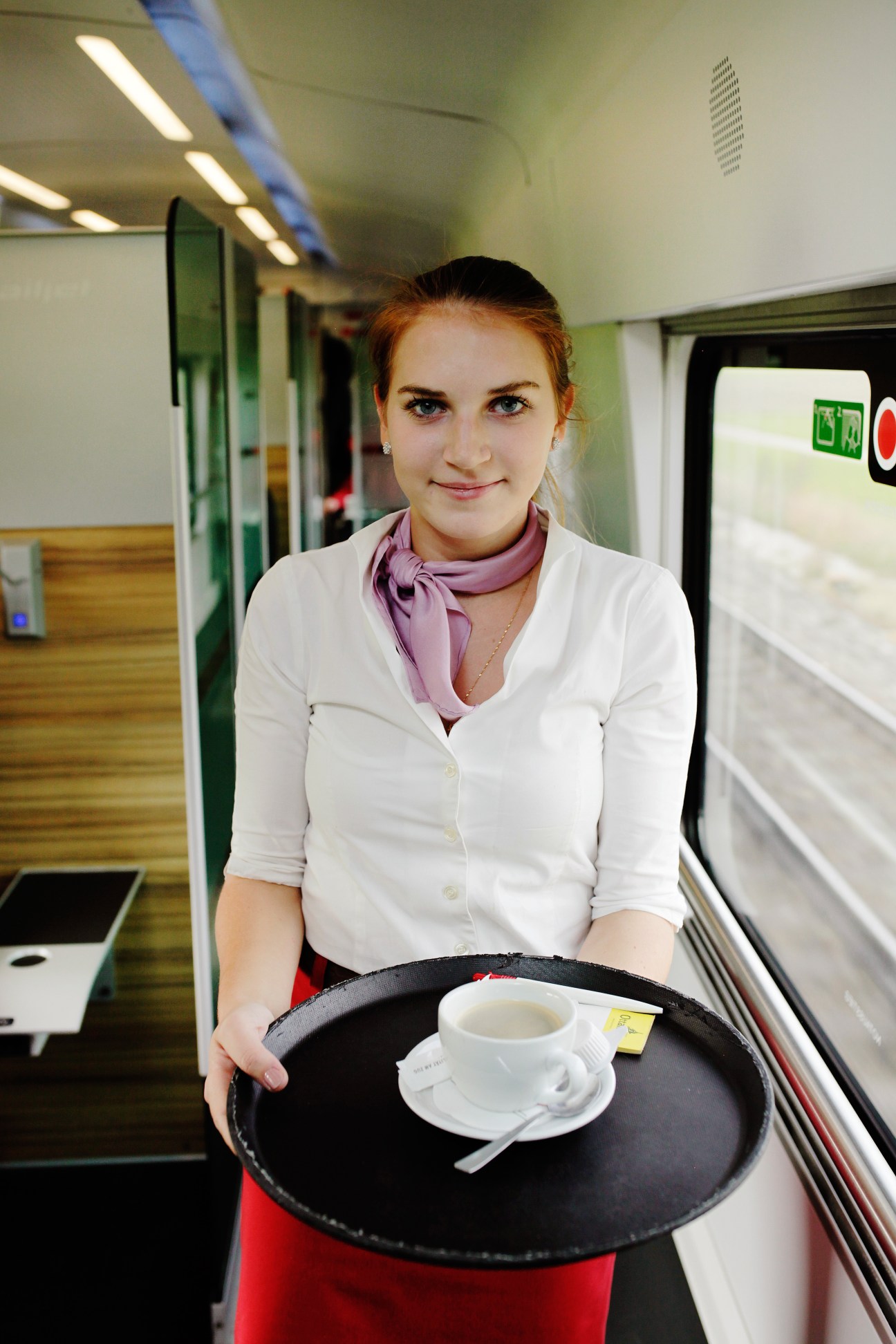 Flight attendant serving coffee on ÖBB's Railjet train between Vienna and Munich