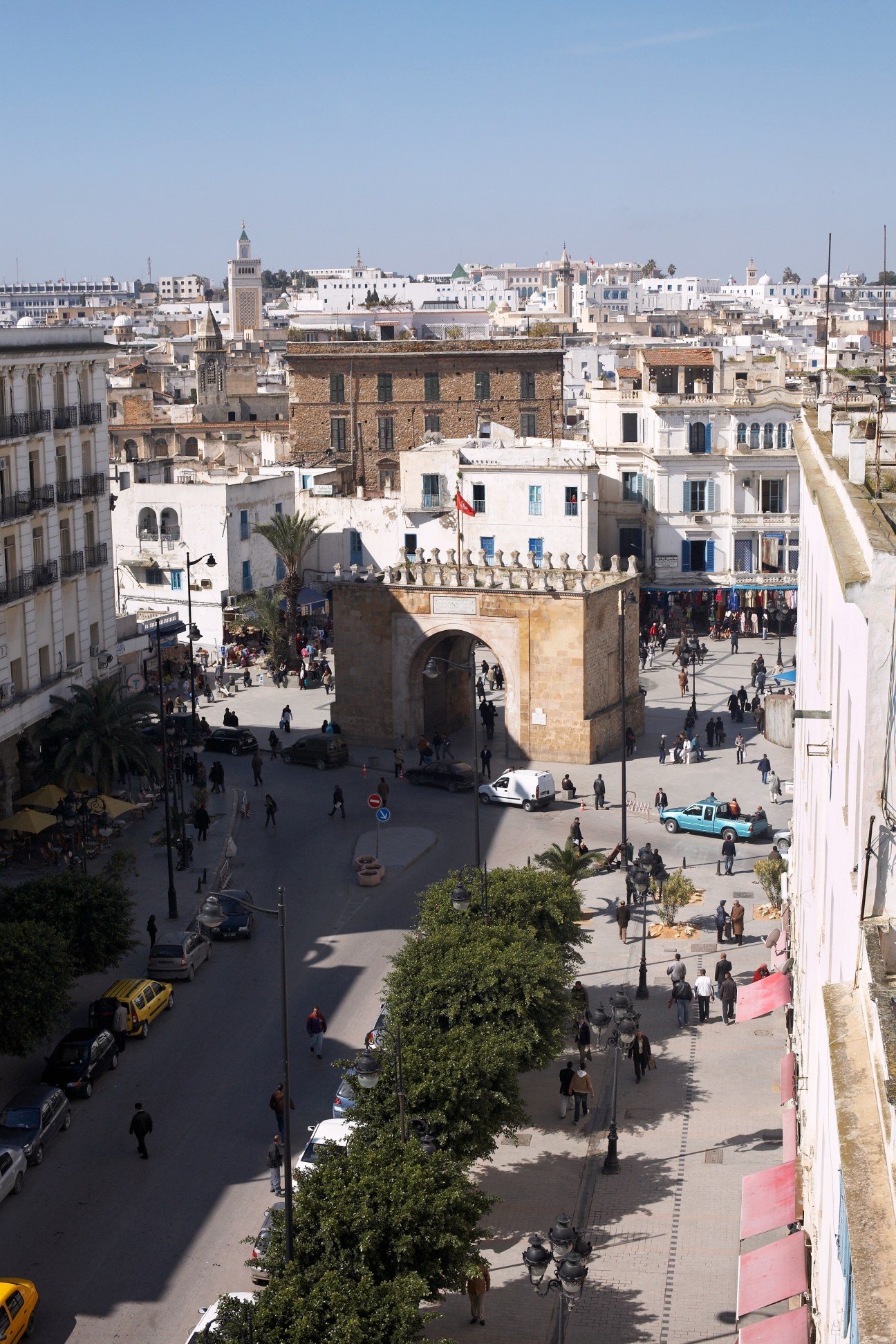 Aerial view of Porte de France gateway showing the boundary between modern Tunis and the ancient medina with white buildings and minaret.