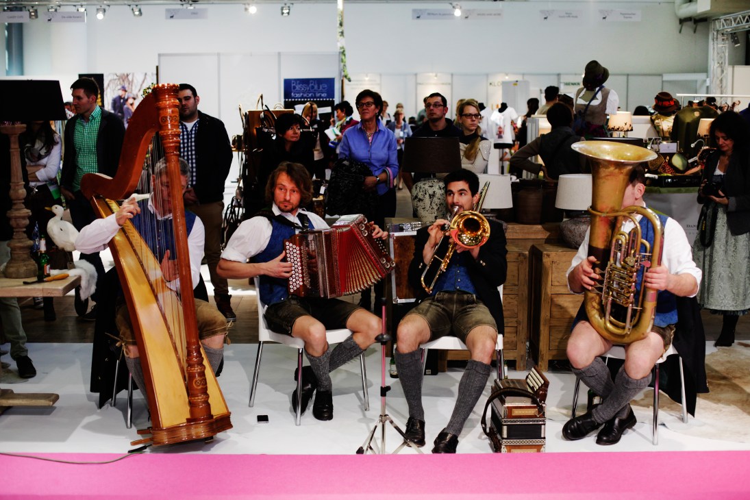Musicians in traditional Bavarian lederhosen and waistcoats perform with harp, accordion, trumpet and saxophone at the Tracht & Country fair.