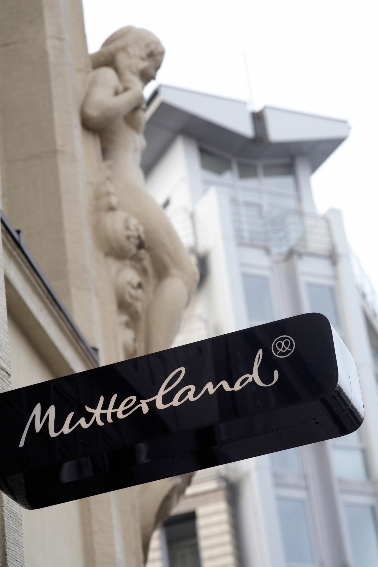 Mutterland storefront sign with sculptural architectural detail on St Georg building facade.