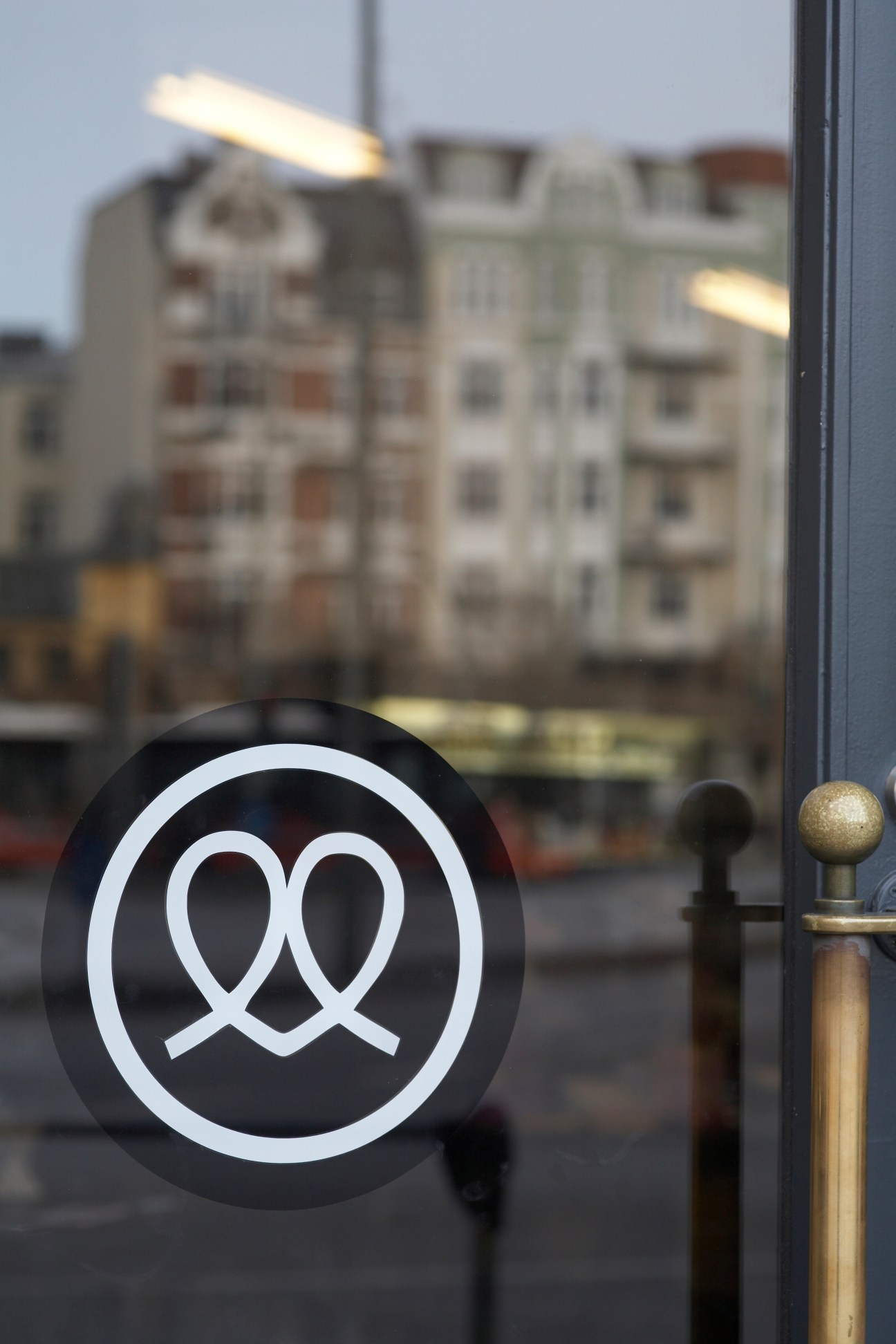 Mutterland logo on storefront window with Hamburg street and buildings reflected behind.