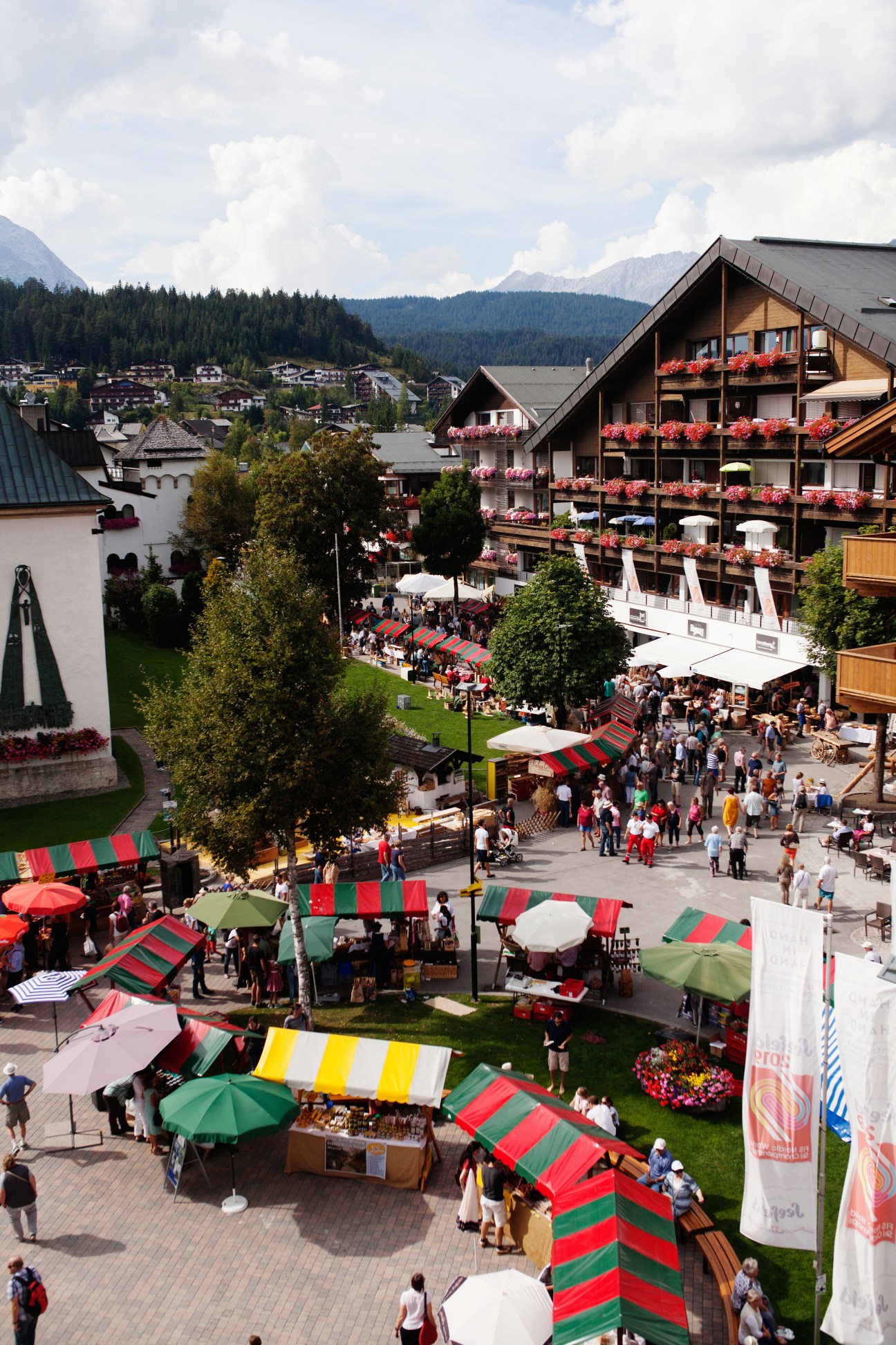 Aerial view of Traditional Tyrolean Handcraft Festival with colorful market stalls and crowds in alpine village