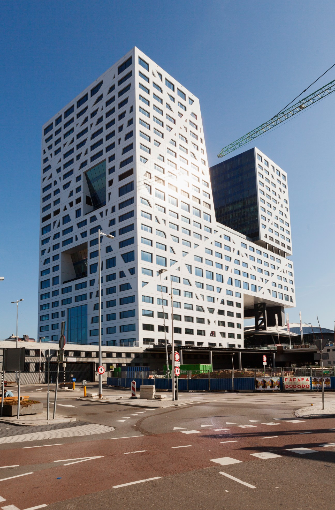 Modern white residential towers above Utrecht's central station with a gleaming glass and steel structure beneath.