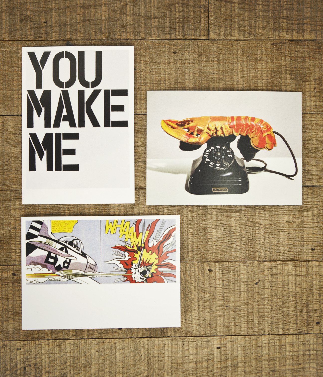 Three museum postcards displayed on a wooden surface featuring artwork from Tate Modern.