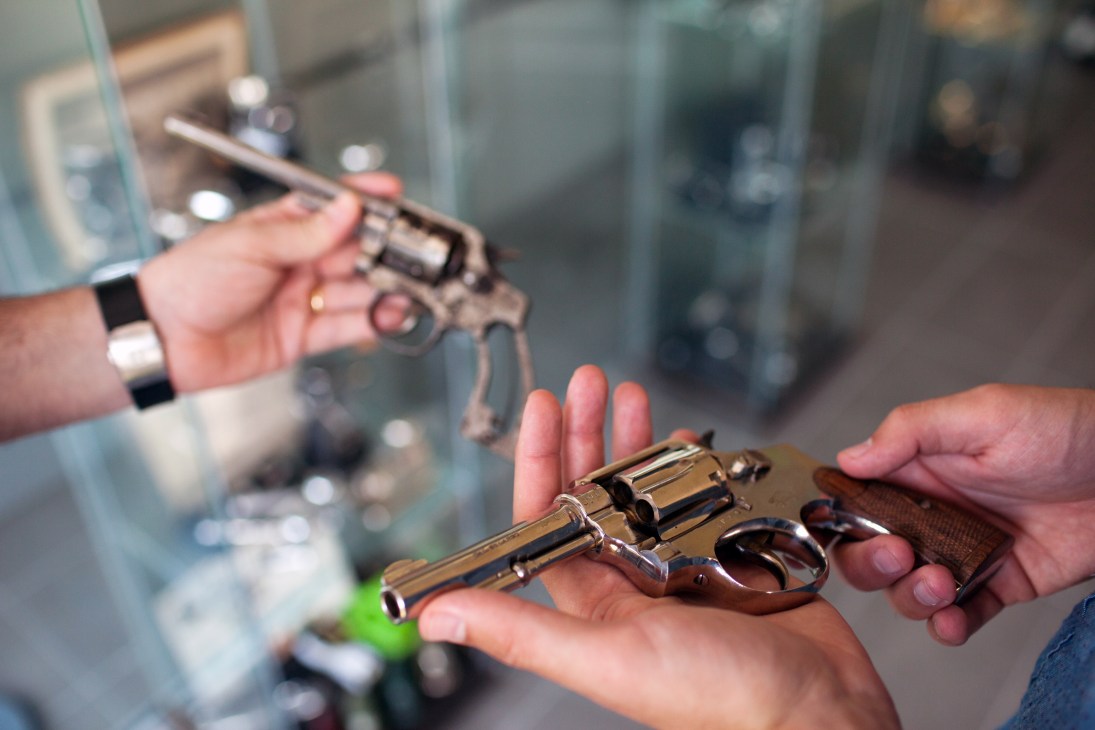 Hands holding two vintage .32-calibre revolvers from the 1920s, El Casco's original firearms products.