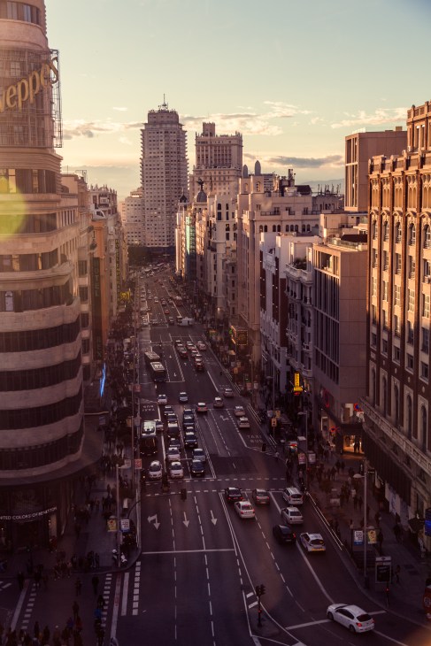 Aerial view of Gran Vía in Madrid at dusk with historic buildings and traffic.