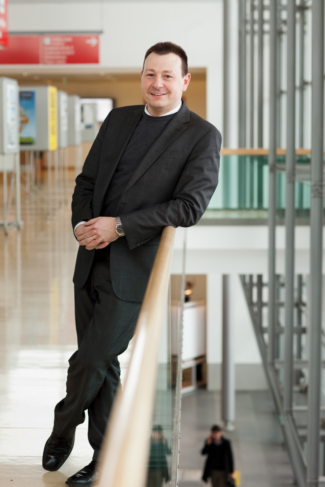 Mirko Arend, BAU exhibition director, standing in a modern corridor with metal railings.
