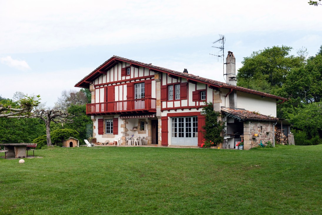 Traditional Basque farmhouse with red-and-white timber framing and red shutters in Saint-Jean-de-Luz