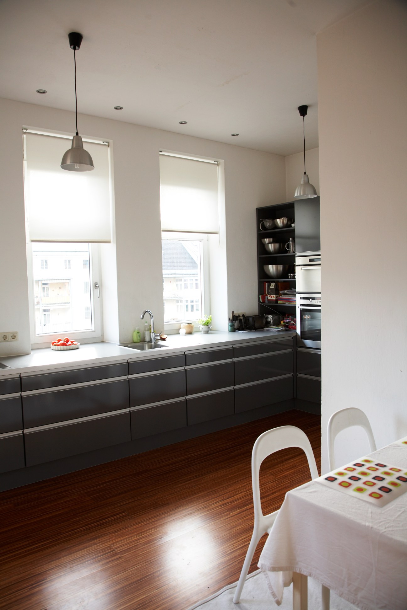 Modern kitchen with black cabinetry, stainless steel appliances, and large windows overlooking Innsbruck.