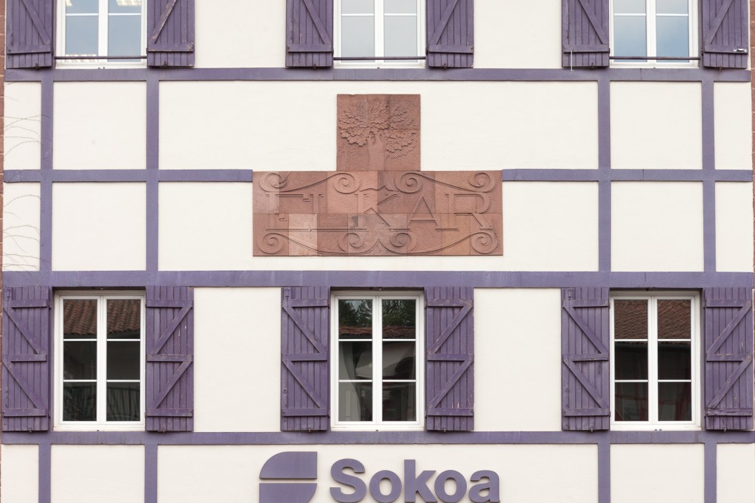 Half-timbered Basque building with purple timber framing, white infill, and Sokoa signage.