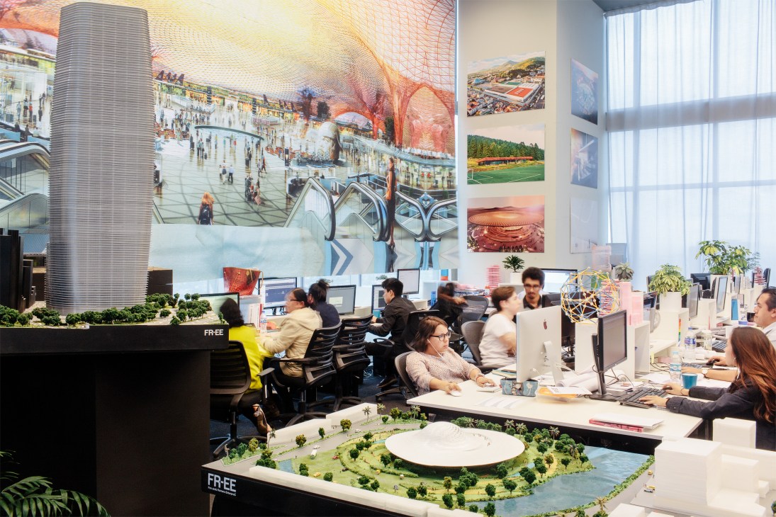 FR-EE architecture firm employees work at desks in a modern Mexico City office with large windows and architectural models on display.