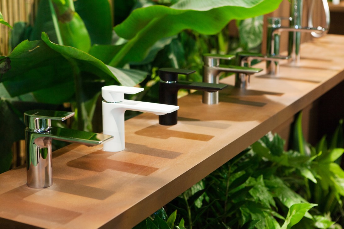 Piano faucet by Treemme on wooden counter with tropical plants in background