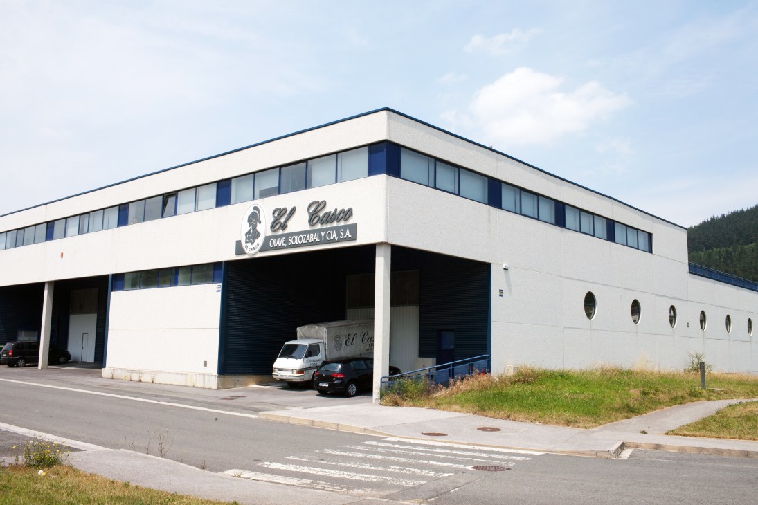 El Casco's modern white factory building with blue trim in Elgeta, Spain, featuring the company logo and name on its facade.