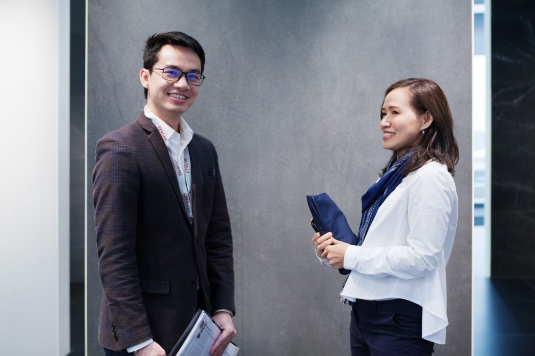 Two Cotto staff members standing together at the Cersaie trade fair in Bologna
