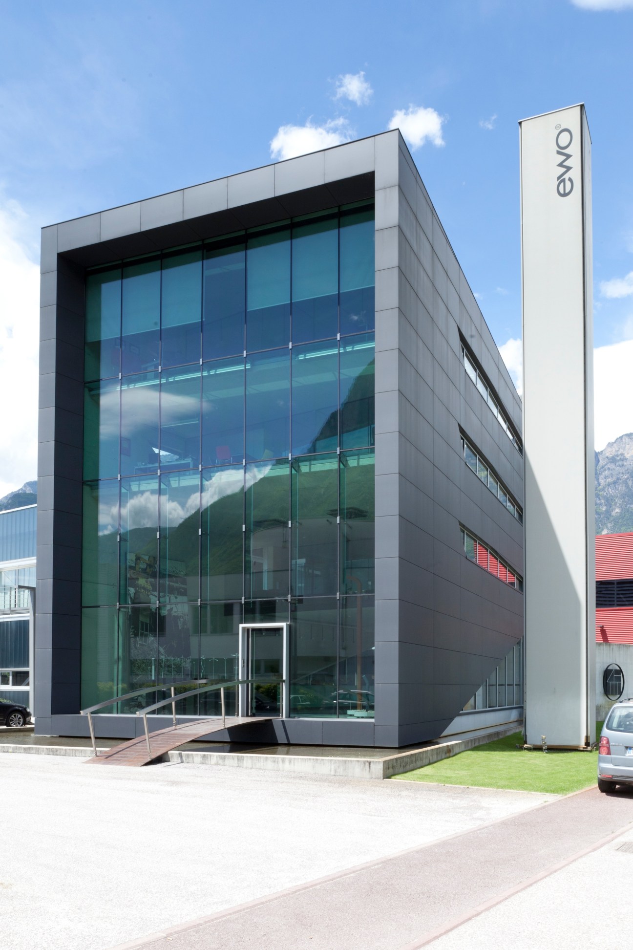 Ewo's modern headquarters building with glass facade and white signage in South Tyrol.