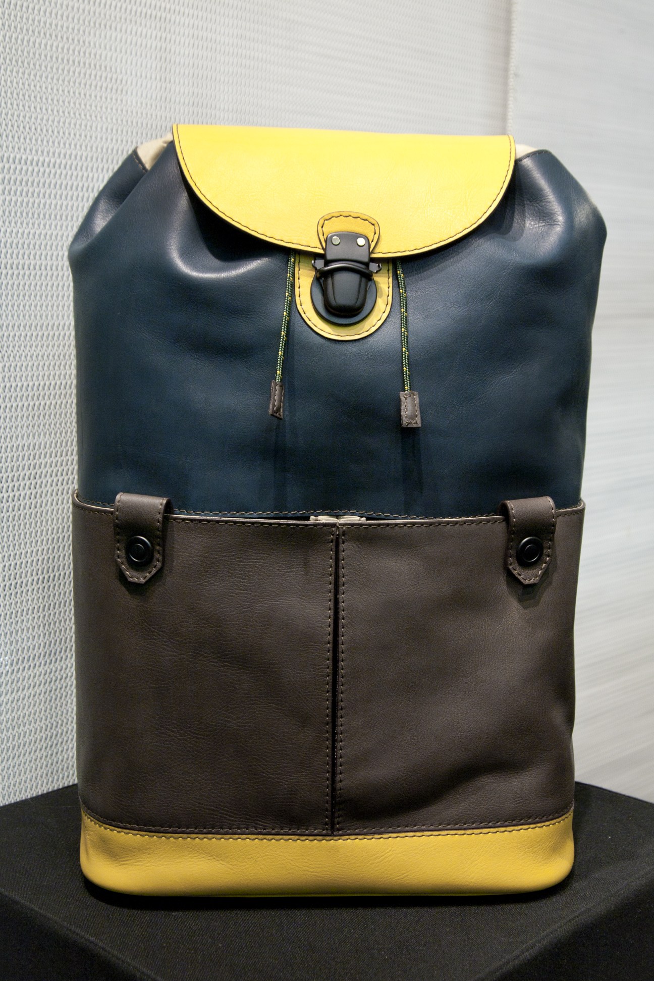 Ghongjord bag with yellow and navy leather color-blocking and metal closure hardware.