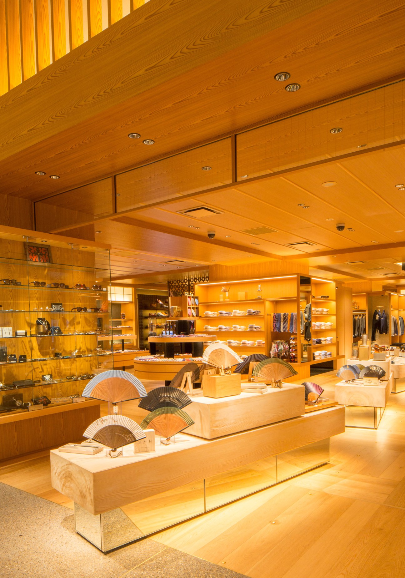 Warm wooden interior of Isetan Mitsukoshi retail space with illuminated display shelves and product showcases.