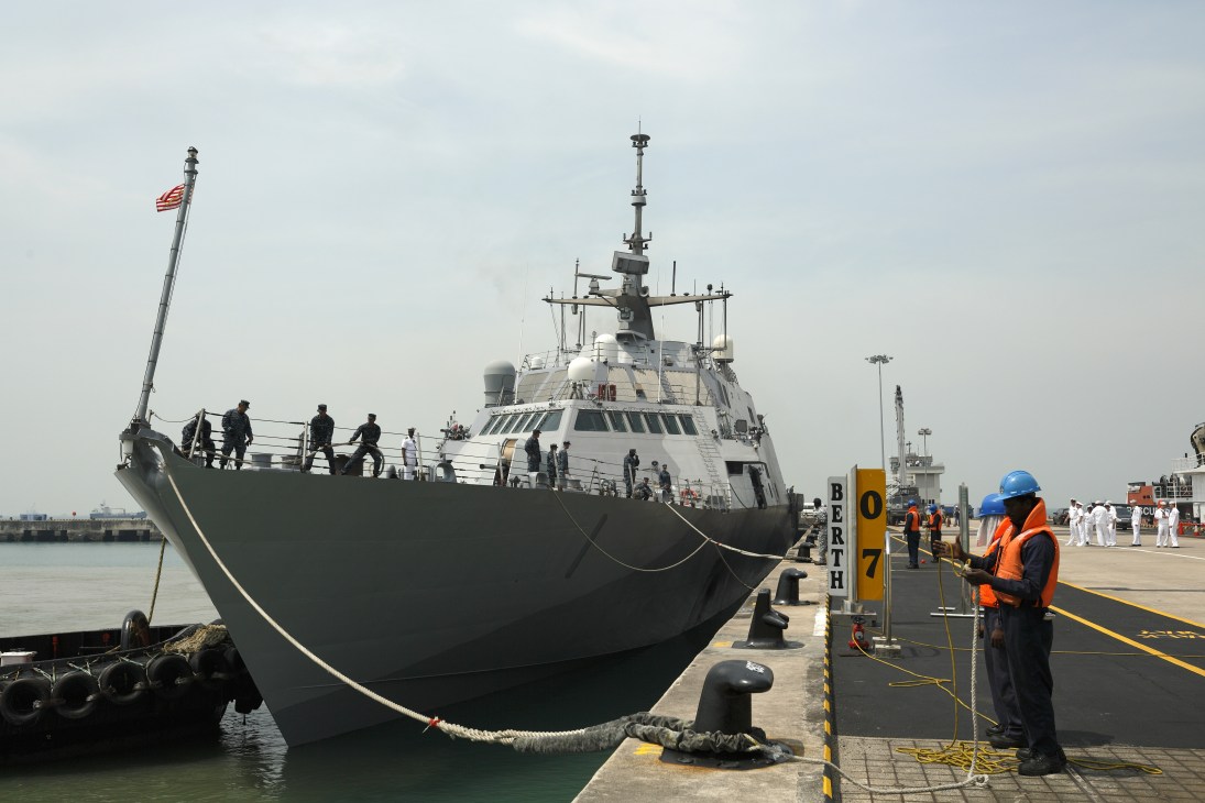 USS Freedom Littoral Combat Ship docked at Changi Naval Base with mooring lines secured.