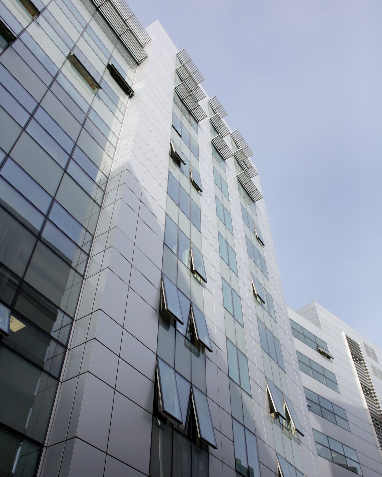 Modern grey high-rise building with glass and metal facade housing La Repubblica newspaper offices in Rome's Garbatella district.
