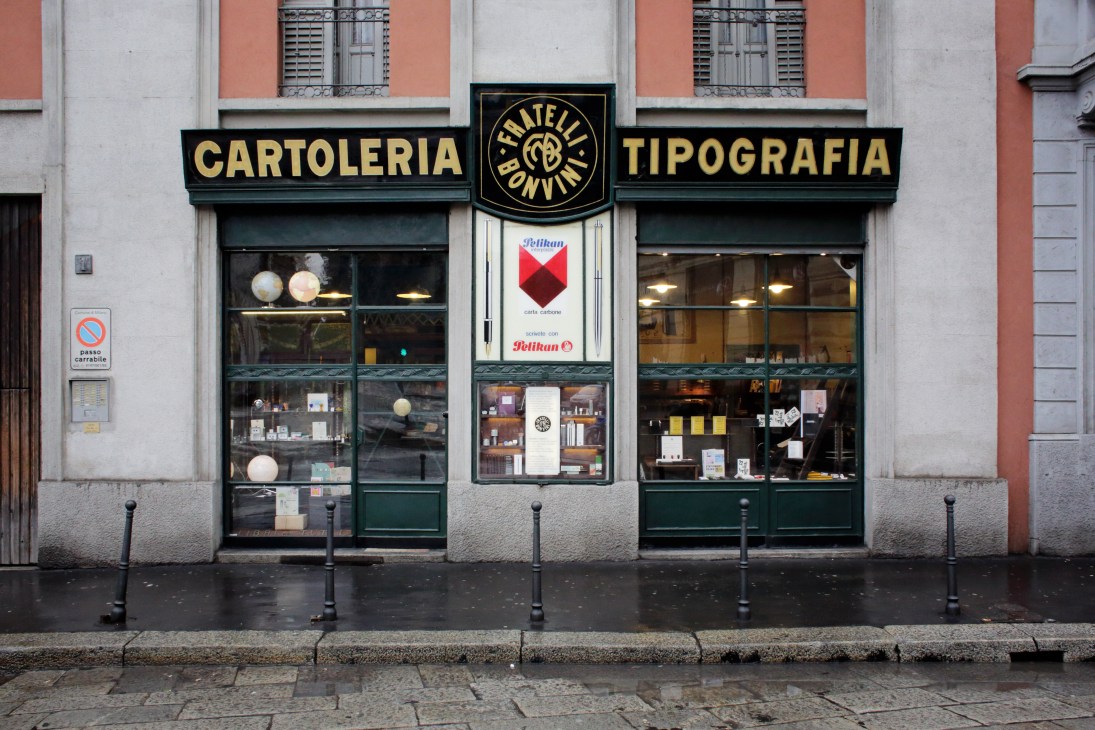Fratelli Bonvini storefront in Milan with green signage reading 'Cartoleria Tipografia' and display windows showing stationery products.