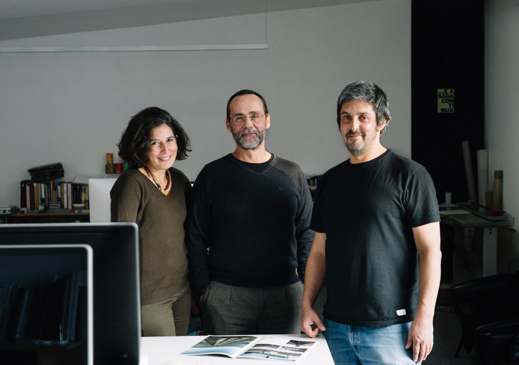 Three P-06 founders standing in a modern office space with white walls and bookshelves.