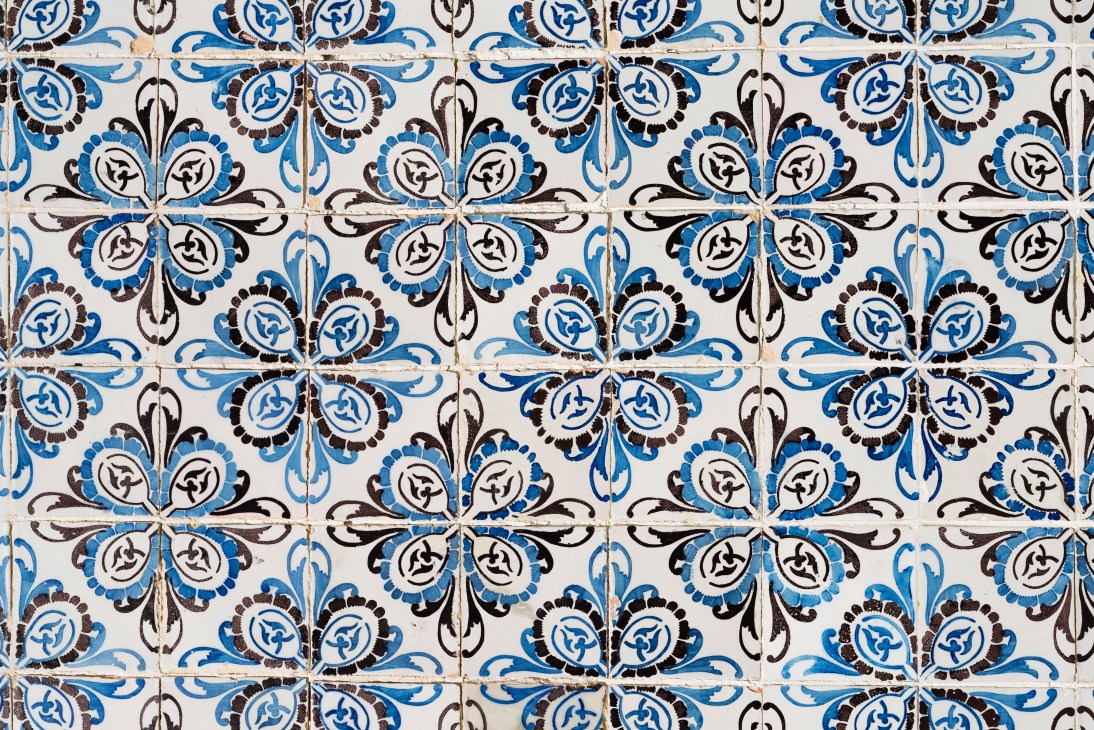 Traditional blue and white ceramic tiles with intricate floral and geometric patterns covering a wall surface.