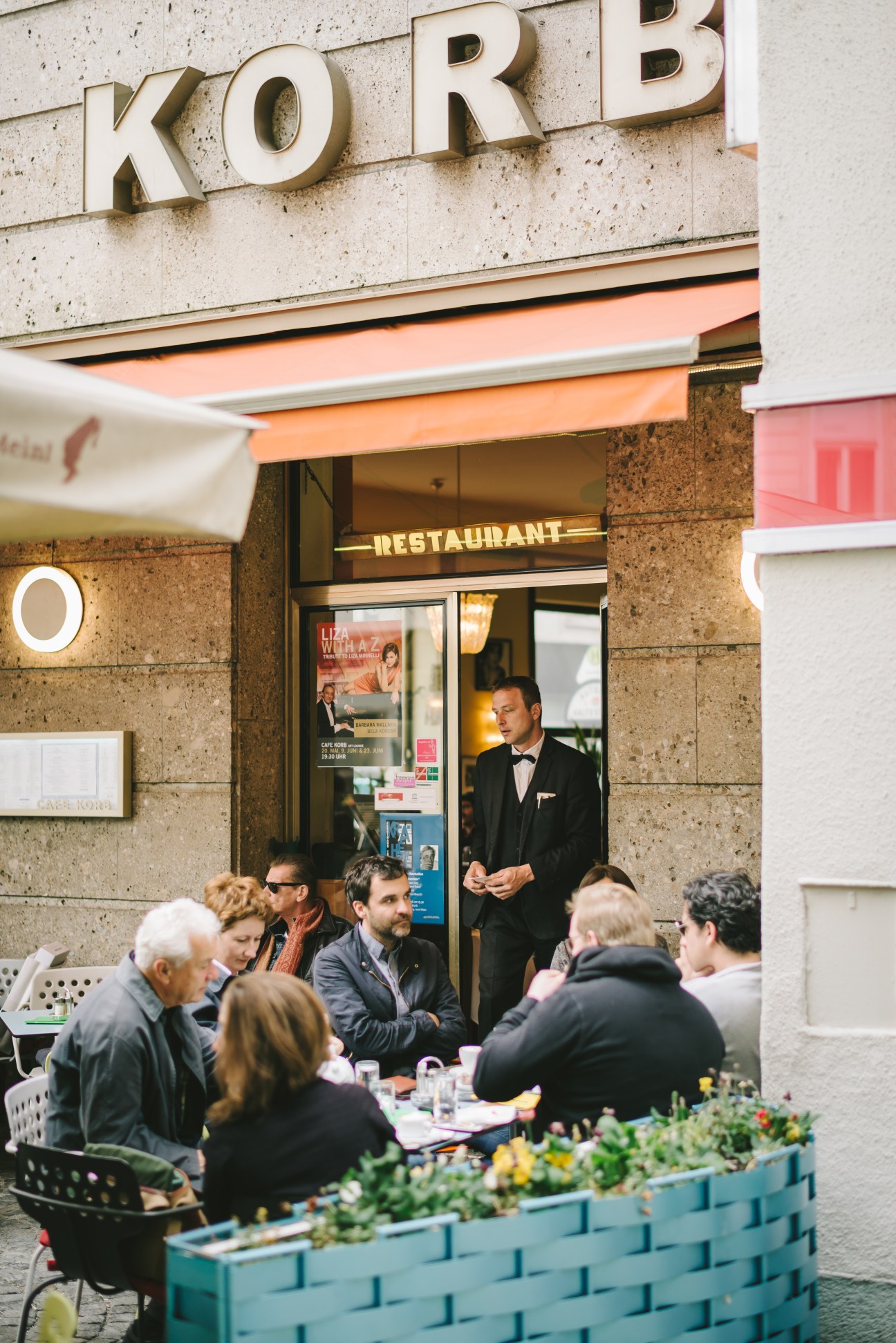 Falter editors and staff gathered around an outdoor table at Café Korb in Vienna for an editorial meeting.