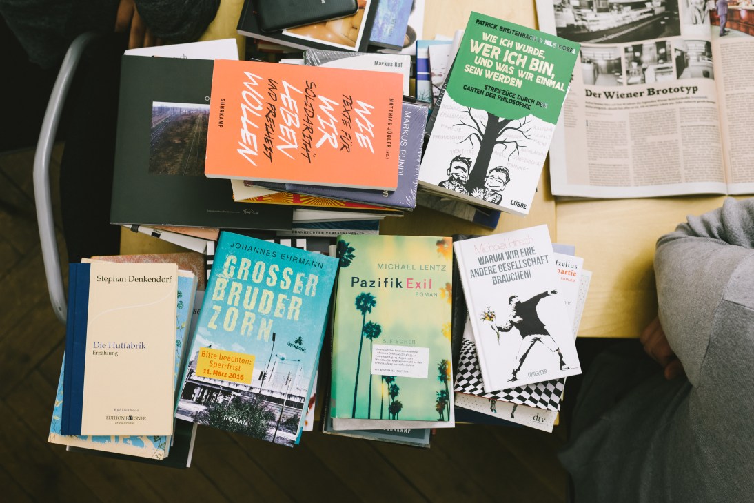 Review copies of books and publications arranged on a conference room table.