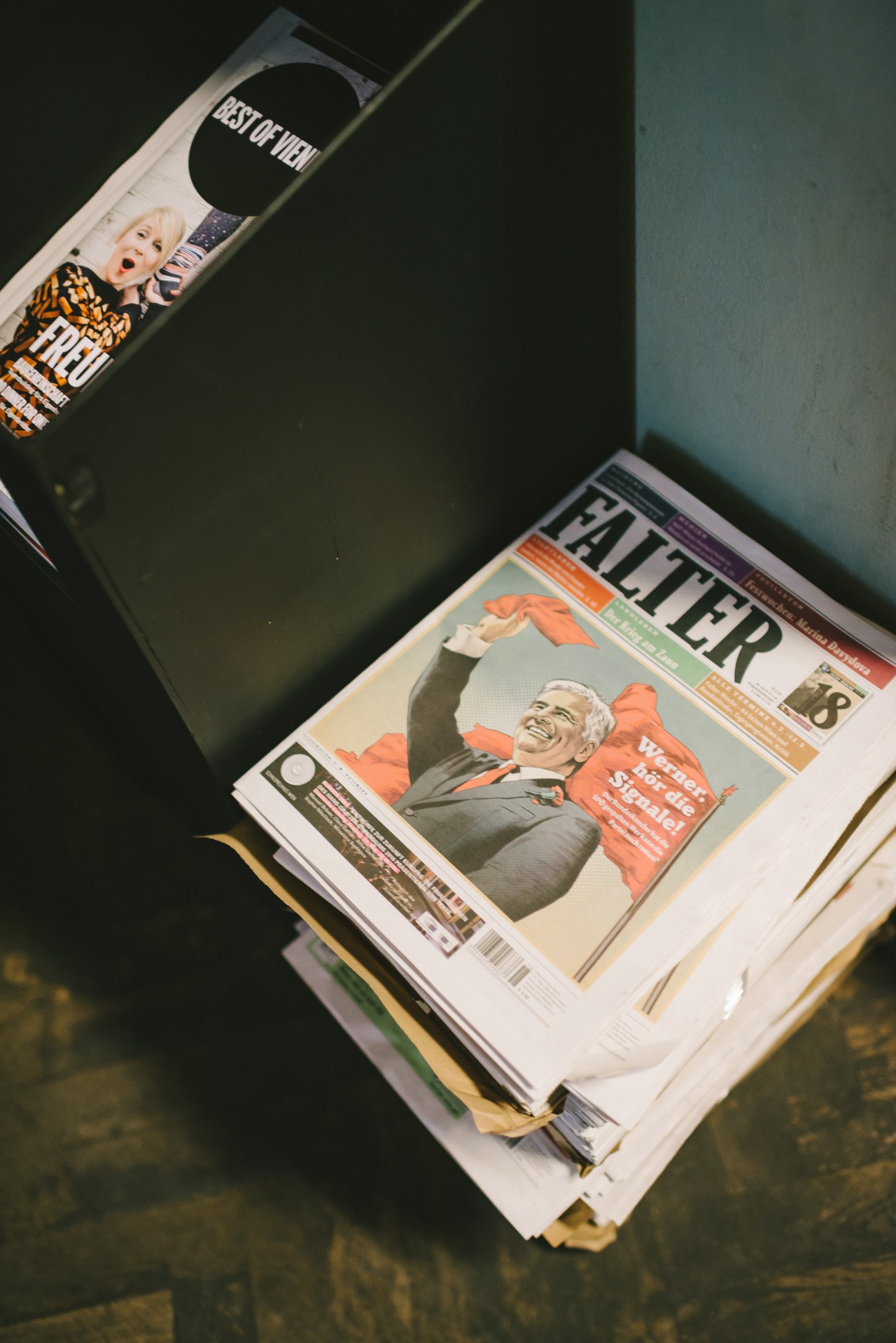 Falter magazine covers and special editions displayed together, showing the publication's tabloid format and design.