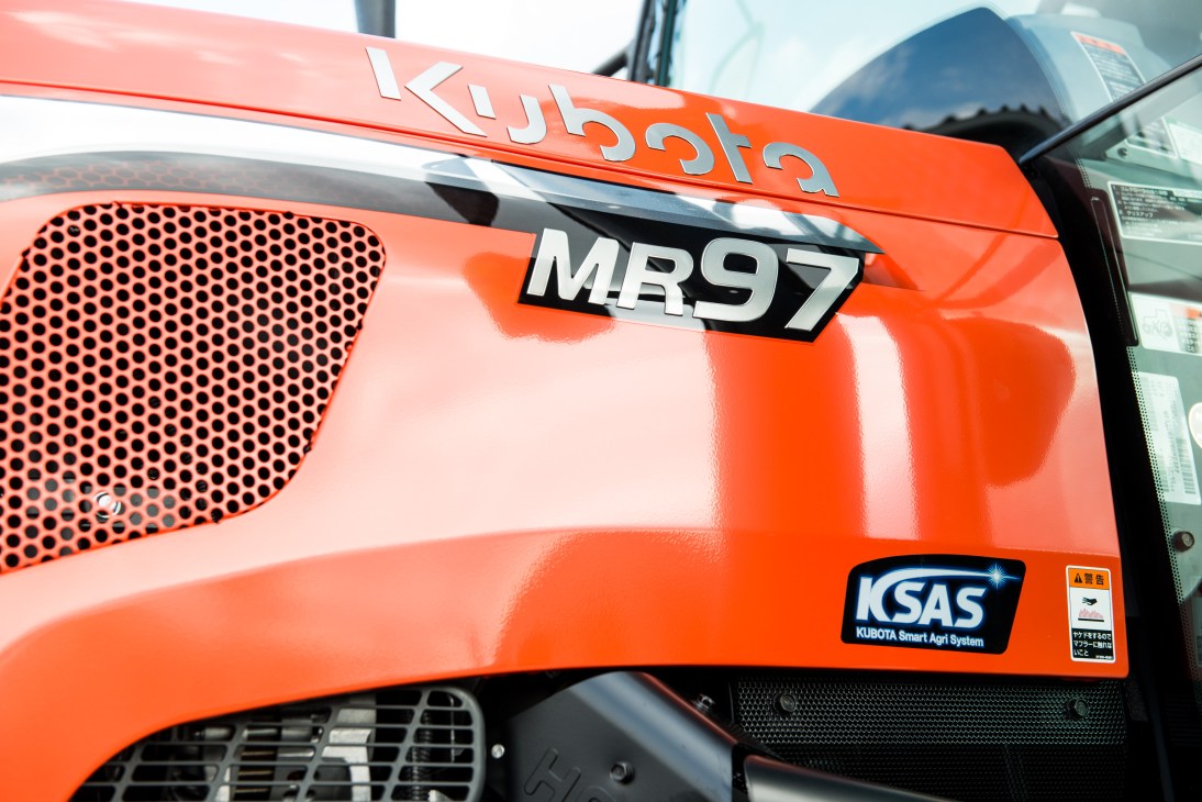 Close-up of an orange Kubota MR97 tractor showing the perforated grille, hood badging, and KSAS smart farming system branding.