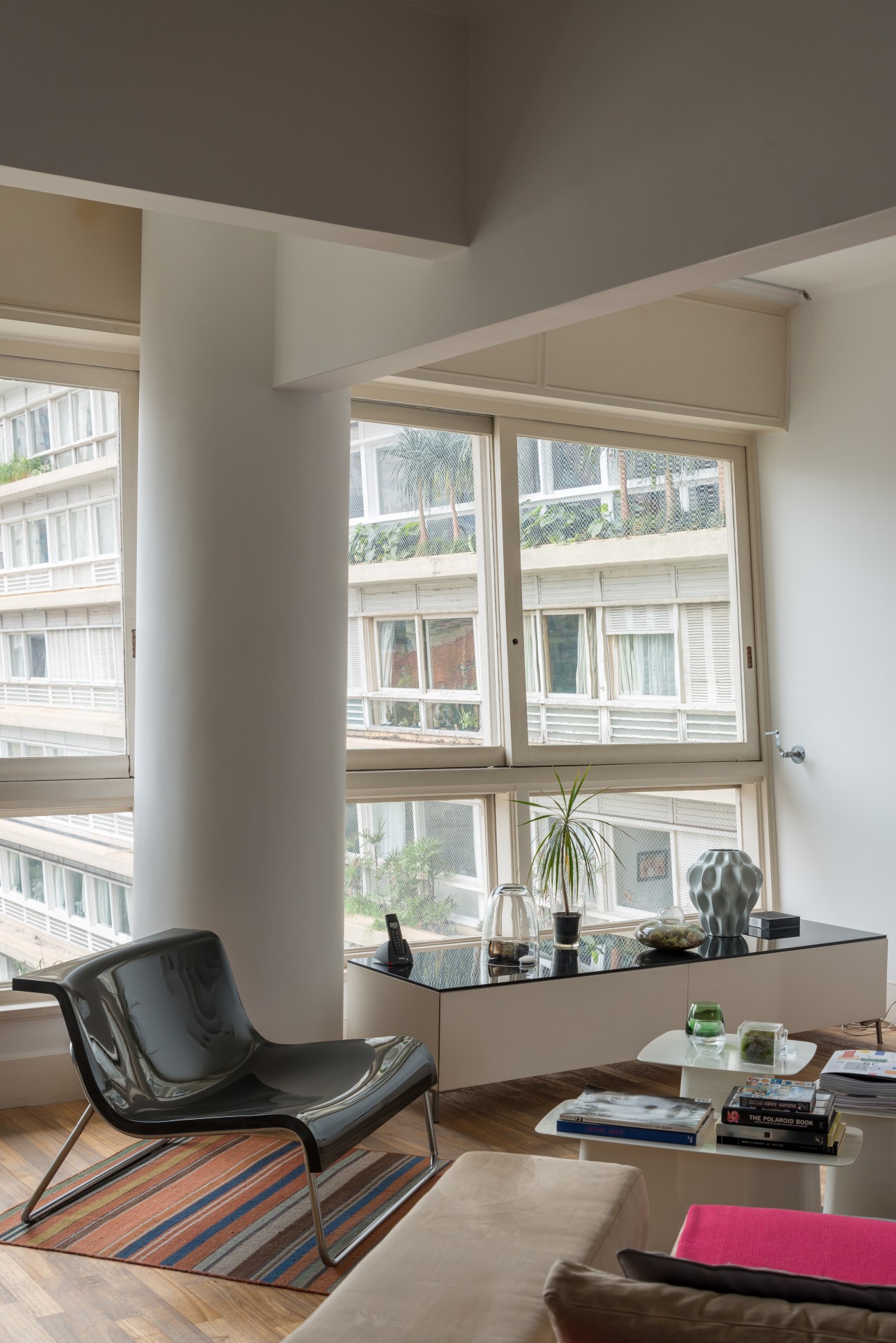 Modern living room with floor-to-ceiling windows overlooking the Bretagne Building's internal courtyard and other residential structures.