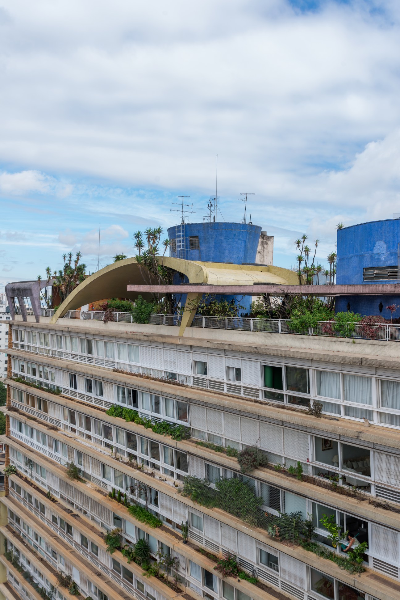 Bretagne Building's east façade showing horizontal concrete balconies with white railings and large windows.