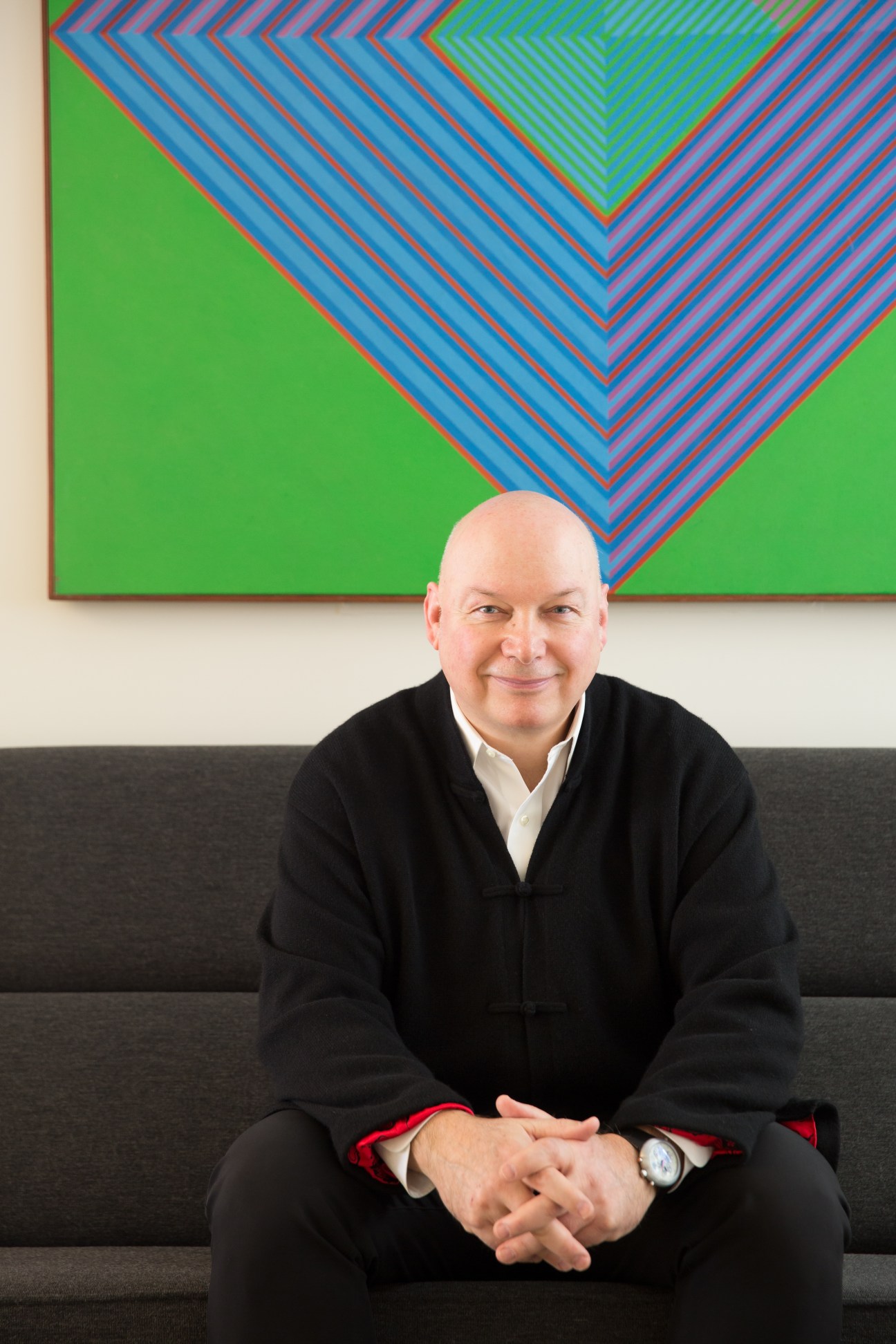 Architect Tarek El-Khatib of Zeidler Partnership seated on a grey sofa wearing a black jacket