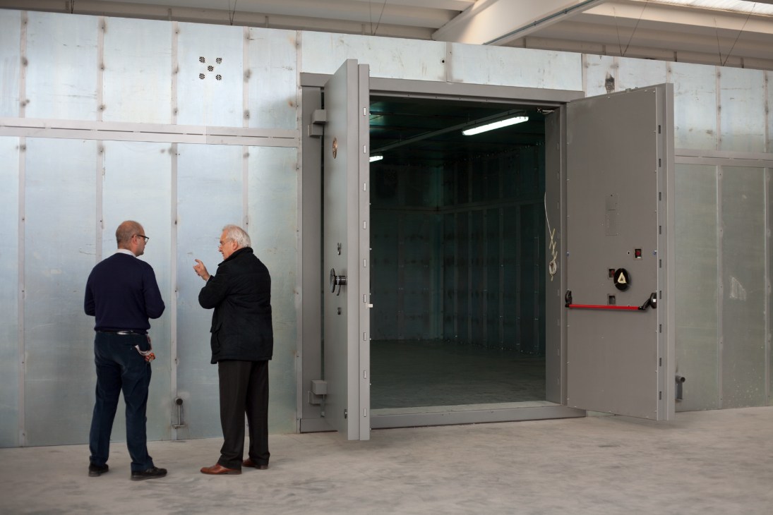 Giorgio Amedeo inspects a large vault door assembly at an artwork storage facility in Milan.