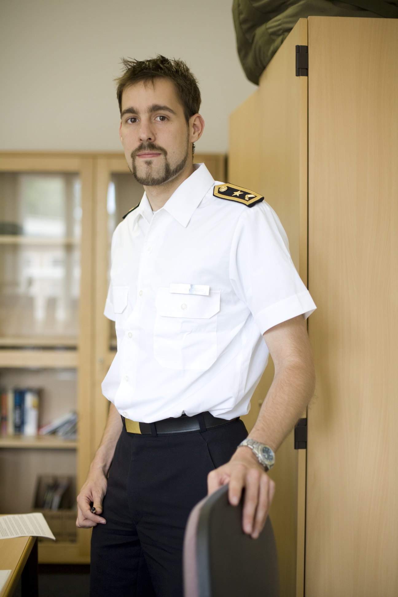 Journalism student Heiko von Ditfurth in white German Bundeswehr naval uniform with shoulder boards standing in an office corridor.