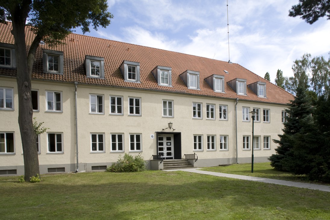Exterior of a cream-colored multi-story building with terracotta roof and dormer windows, housing Y magazine's editorial offices.