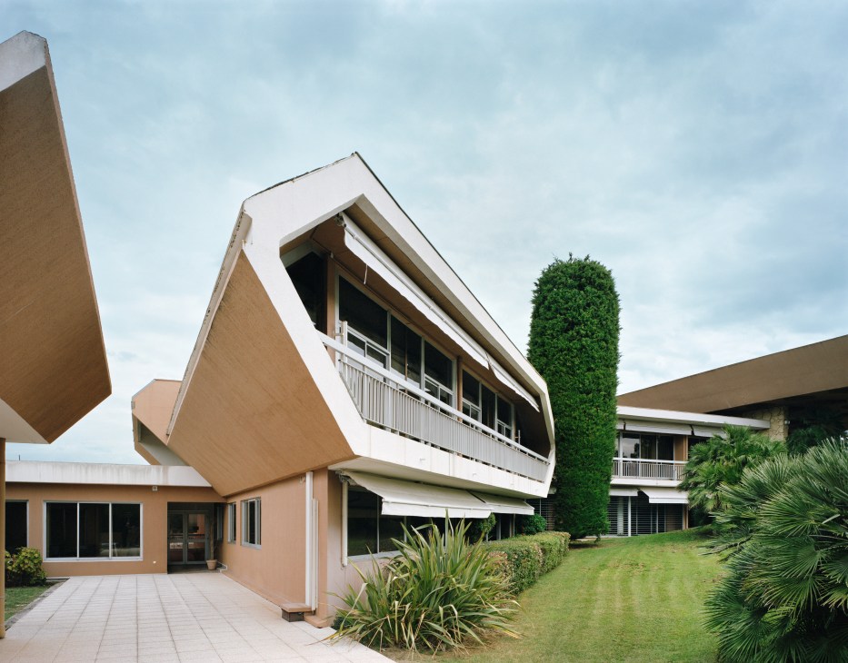 GSF building exterior with white trim and brown-toned walls featuring hexagonal architectural patterns and a curved roofline.