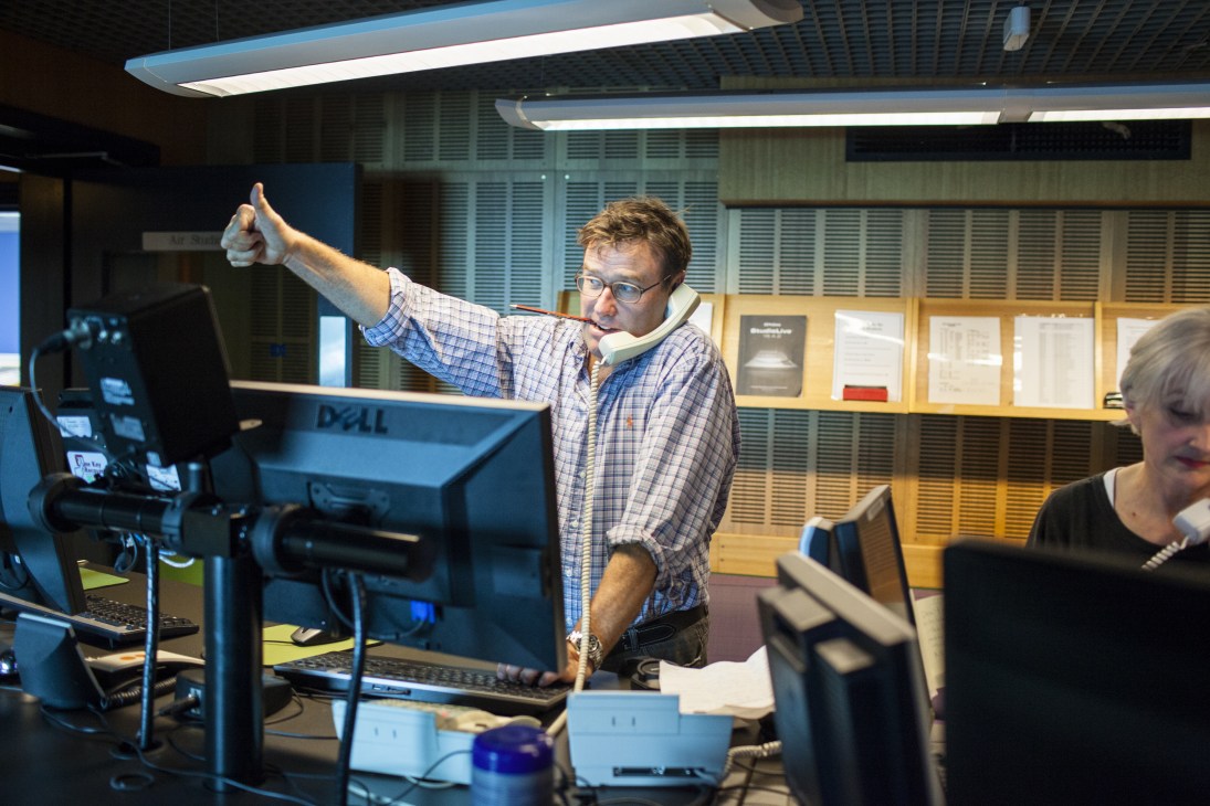 Producer Steven Turner gives a thumbs up gesture in the ABC Radio National control room.