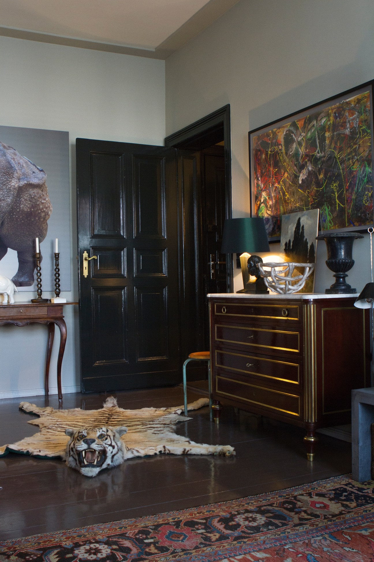 Eclectic Berlin apartment with black doors, artwork, furniture and tiger rug designed by Gisbert Pöppler.