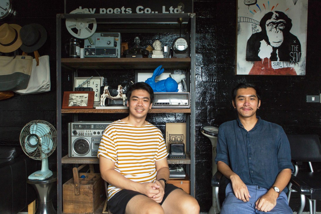 Jiranarong Wongsoontorn and Bopitr Visetnol sitting in vintage-filled workspace with shelves of old electronics and posters