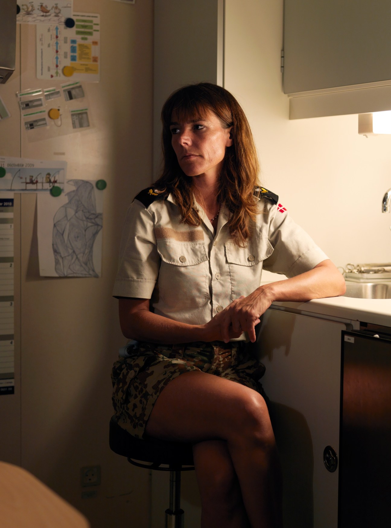 Ship's nurse Raja Burkhave sits in uniform in the medical office aboard HDMS Absalon.