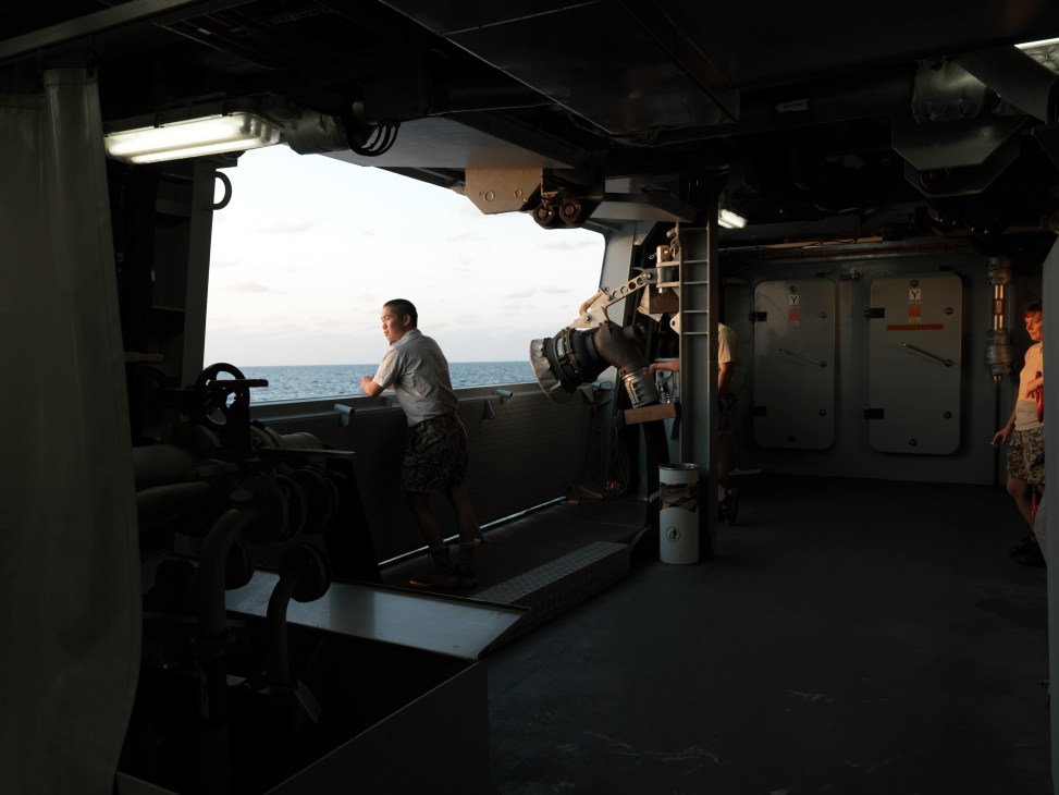 Danish Navy crew member observes the ocean from the weapons deck of HDMS Absalon.