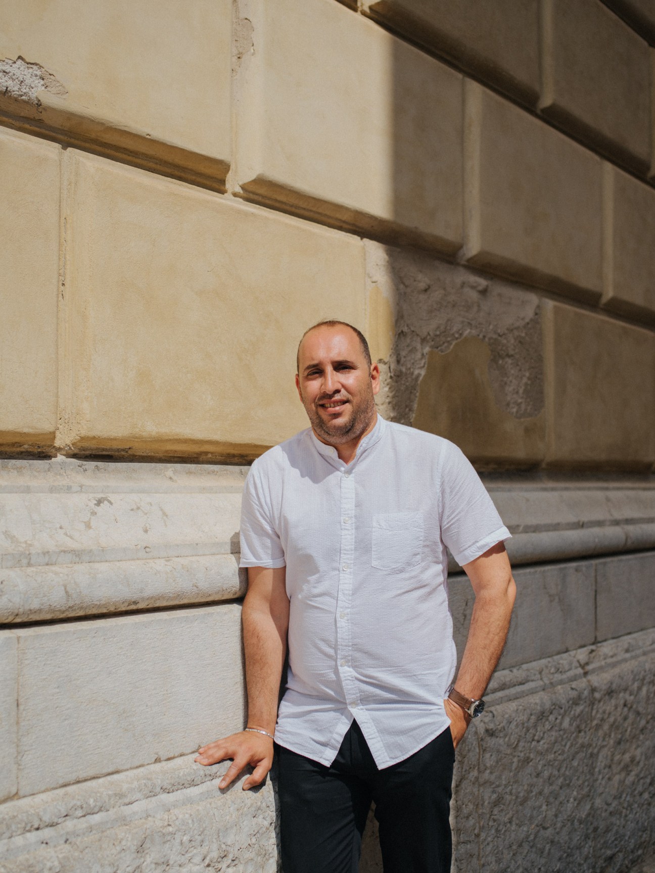 Adham Darawsha, Arab-Israeli doctor and two-time president of the Council of Cultures, standing against a weathered palazzo wall in Palermo.